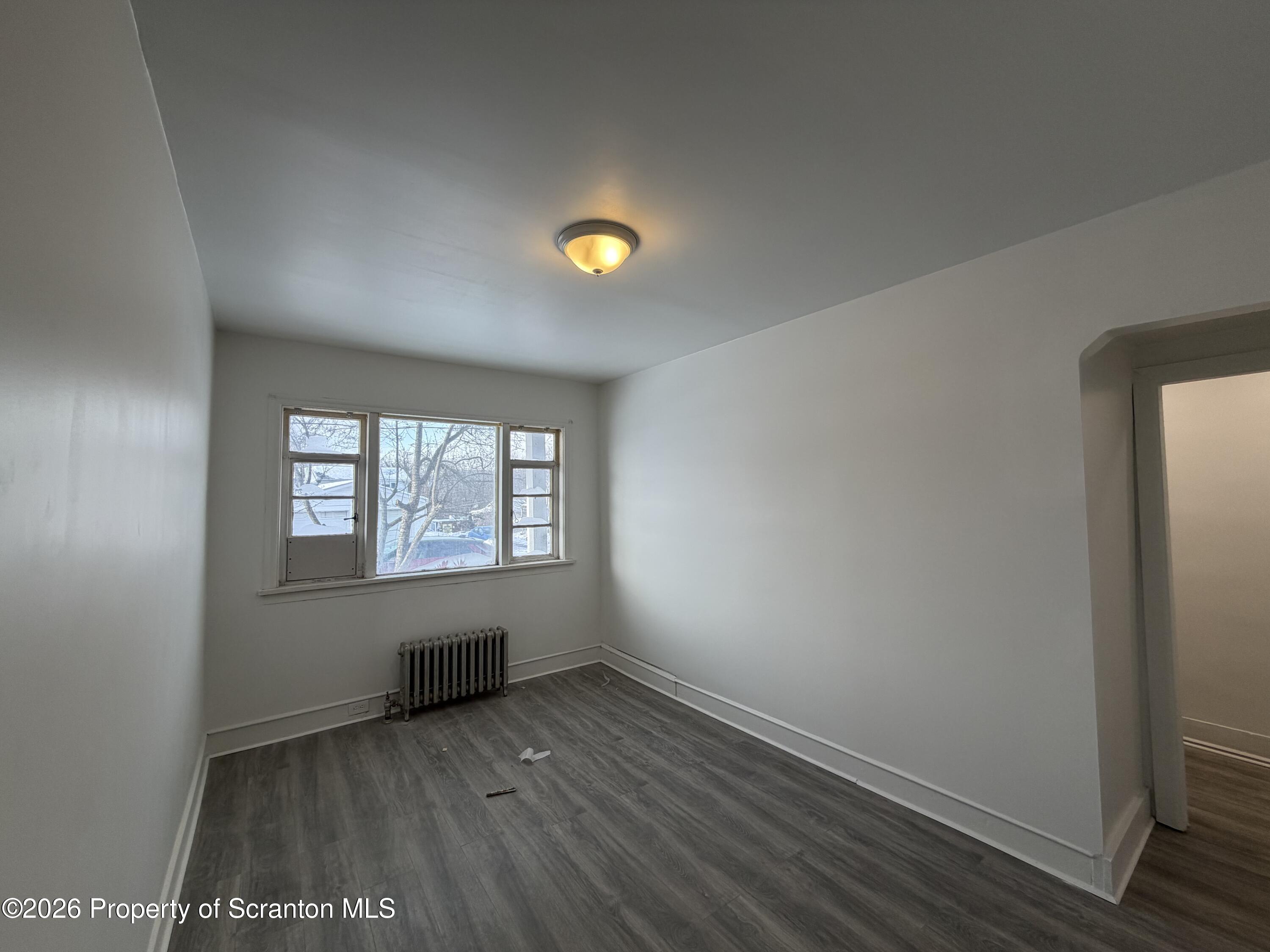 101 Clarkson Street, Unit 1 Jessup, PA 18434 - Photo 8 of 13 an empty room with wooden floor and windows