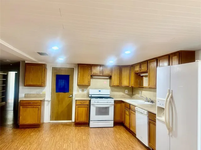 a kitchen with stainless steel appliances a refrigerator and a stove top oven
