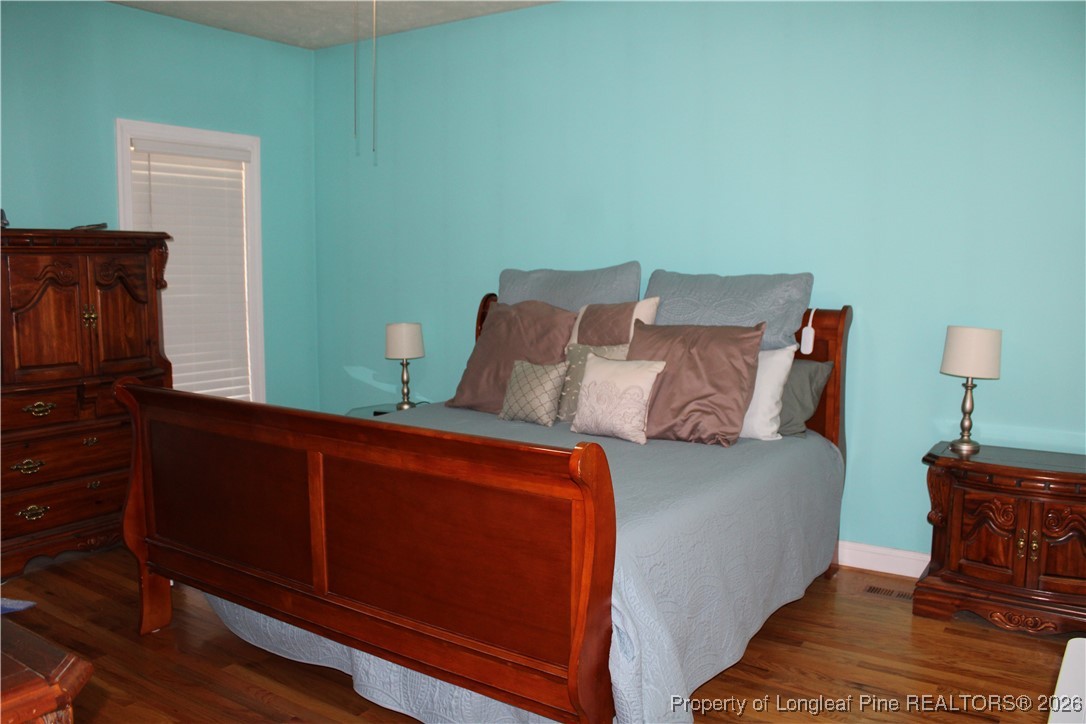 573 Porter Road Hope Mills, NC 28348 - Photo 14 of 29 a bed sitting in a bedroom next to a wooden cabinet