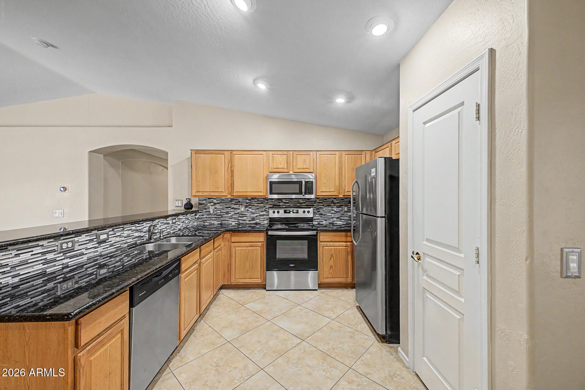 2340 West Apollo Road Phoenix, AZ 85041 - Photo 9 of 26 a large kitchen with granite countertop a sink and refrigerator