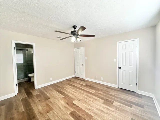 an empty room with closet and a ceiling fan