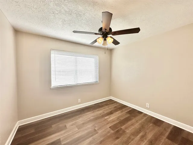 a view of a room with a window and a ceiling fan