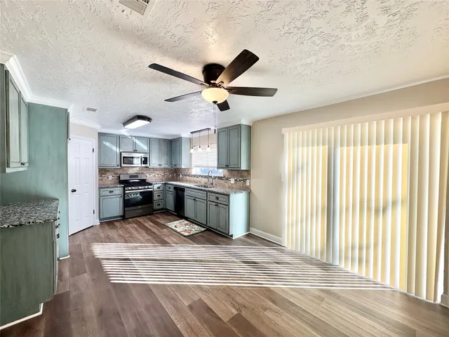 a kitchen with stainless steel appliances granite countertop a stove a sink and a refrigerator