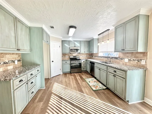 a kitchen with granite countertop stainless steel appliances and cabinets