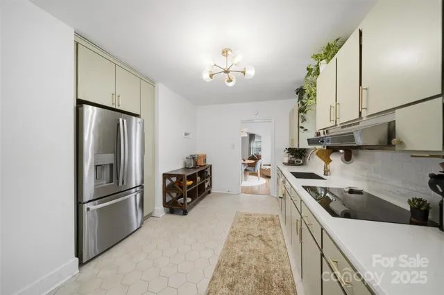 a kitchen with stainless steel appliances granite countertop a refrigerator a sink dishwasher a stove with white cabinets and wooden floor