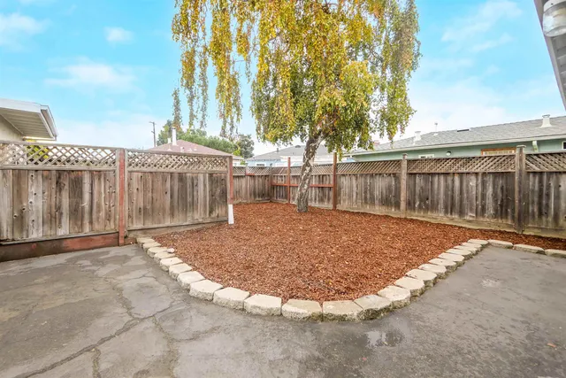 a view of a backyard with white fence
