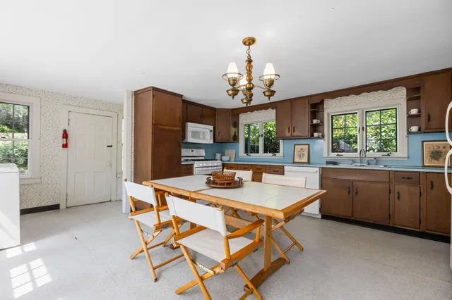 a dining room with a table chairs and kitchen view