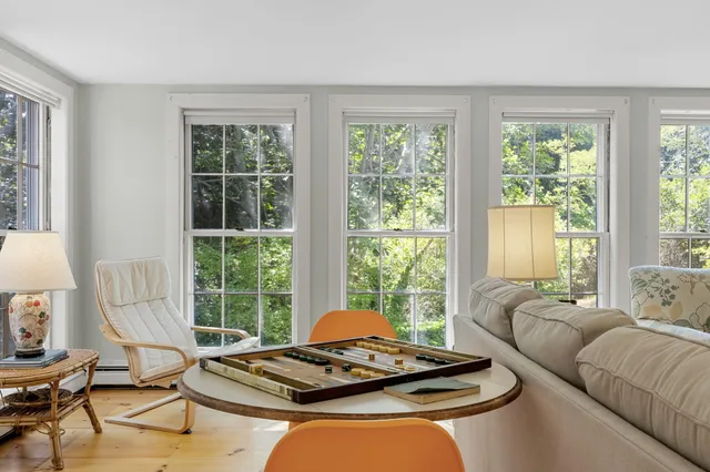 a living room with furniture and floor to ceiling windows