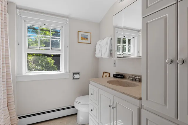 a bathroom with a sink a toilet and a window