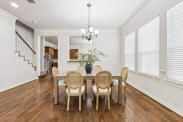 a dining room with furniture a chandelier and wooden floor