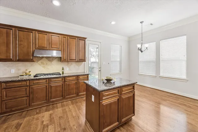 a kitchen with stainless steel appliances granite countertop a sink stove and cabinets