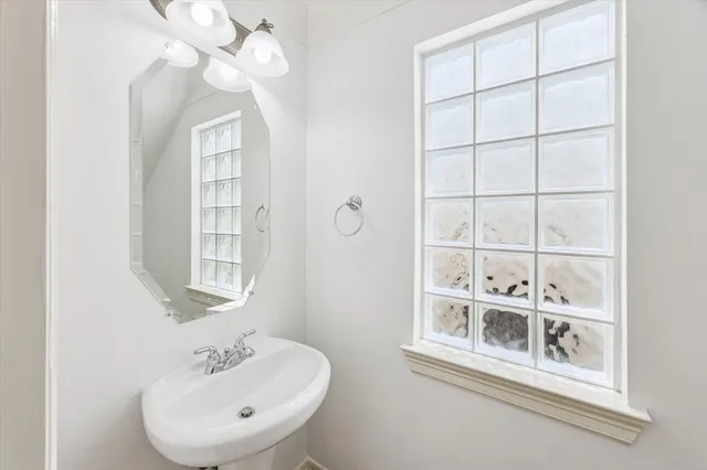 a bathroom with a sink a mirror and a window