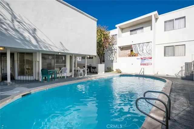 a backyard with table and chairs and potted plants