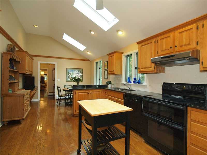 2 Shady Acres Road Darien, CT 06820 - Photo 6 of 18 a kitchen with stainless steel appliances granite countertop a stove a sink dishwasher a dining table and chairs with wooden floor