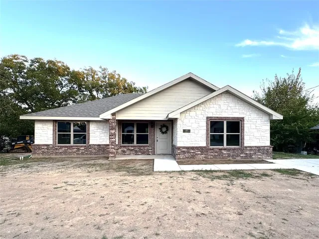 a front view of house with yard and trees
