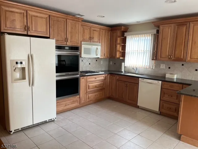 a kitchen with stainless steel appliances granite countertop a refrigerator sink and cabinets