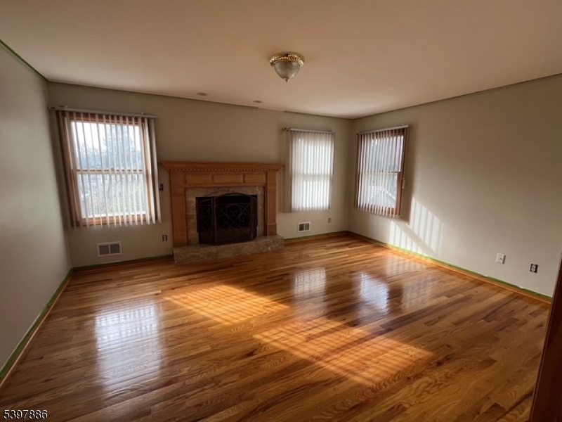 502 Summit Avenue, Unit 1 Westfield, NJ 07090 - Photo 6 of 19 a view of empty room with wooden floor and fireplace