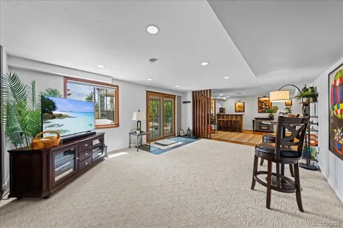 a large living room with stainless steel appliances kitchen island granite countertop a table and chairs in it