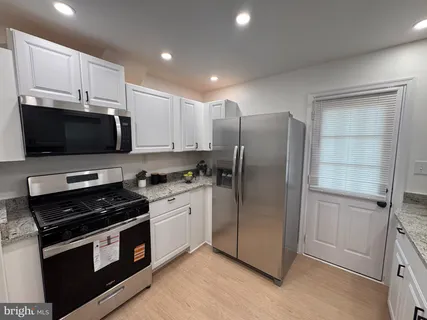 a kitchen with stainless steel appliances and white cabinets