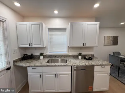 a kitchen with granite countertop cabinets stainless steel appliances a sink and a counter top space