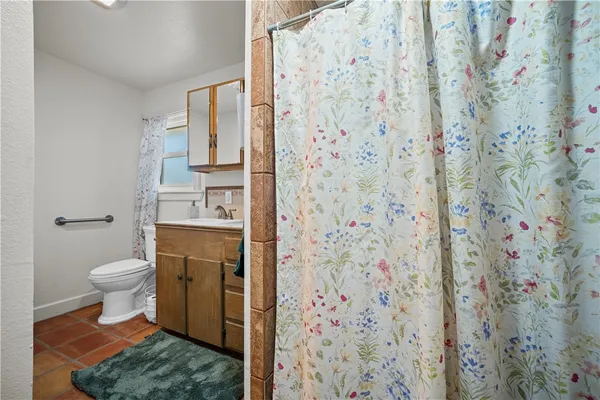 a bathroom with a toilet and a shower curtain