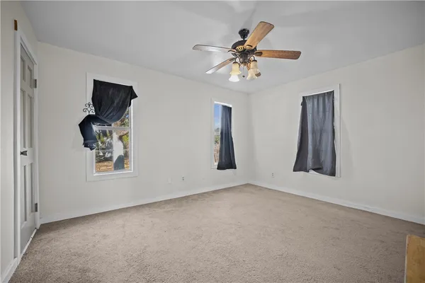 an empty room with windows and cabinet