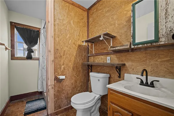 a bathroom with a toilet a sink and mirror