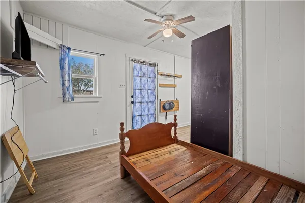 a view of a bedroom with furniture and a ceiling fan