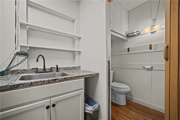 a bathroom with a granite countertop toilet sink and mirror
