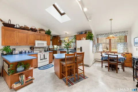 a room with stainless steel appliances kitchen island granite countertop furniture and a view of living room