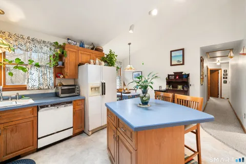 a kitchen with stainless steel appliances granite countertop a sink a refrigerator and a stove