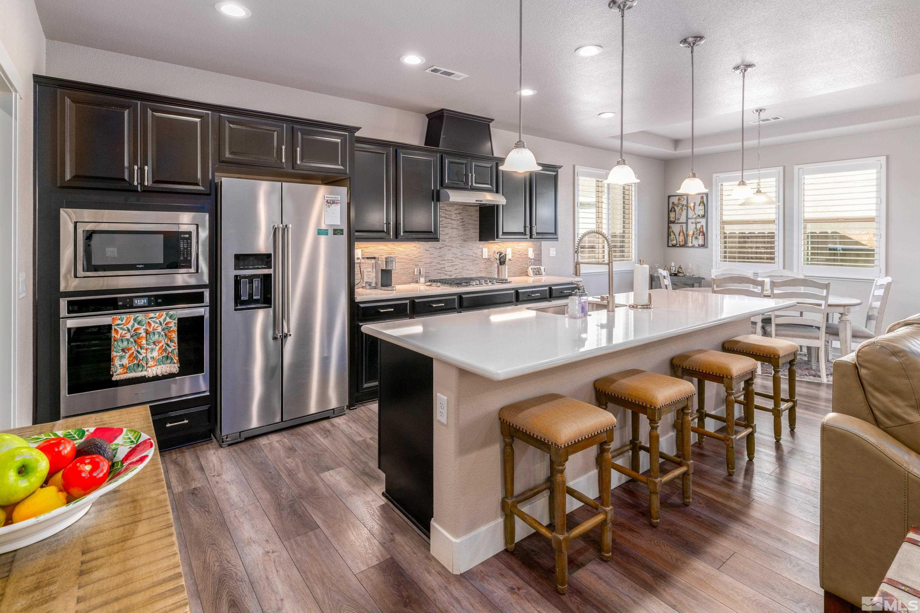 1230 West Cottage Loop Gardnerville, NV 89460 - Photo 6 of 25 a kitchen with stainless steel appliances granite countertop a refrigerator a sink dishwasher a dining table and chairs with wooden floor