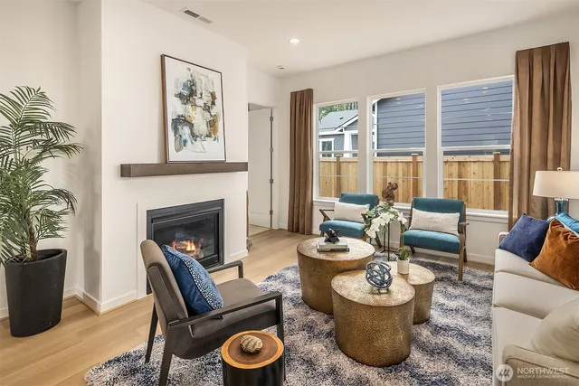 a living room with furniture a fireplace and a potted plant
