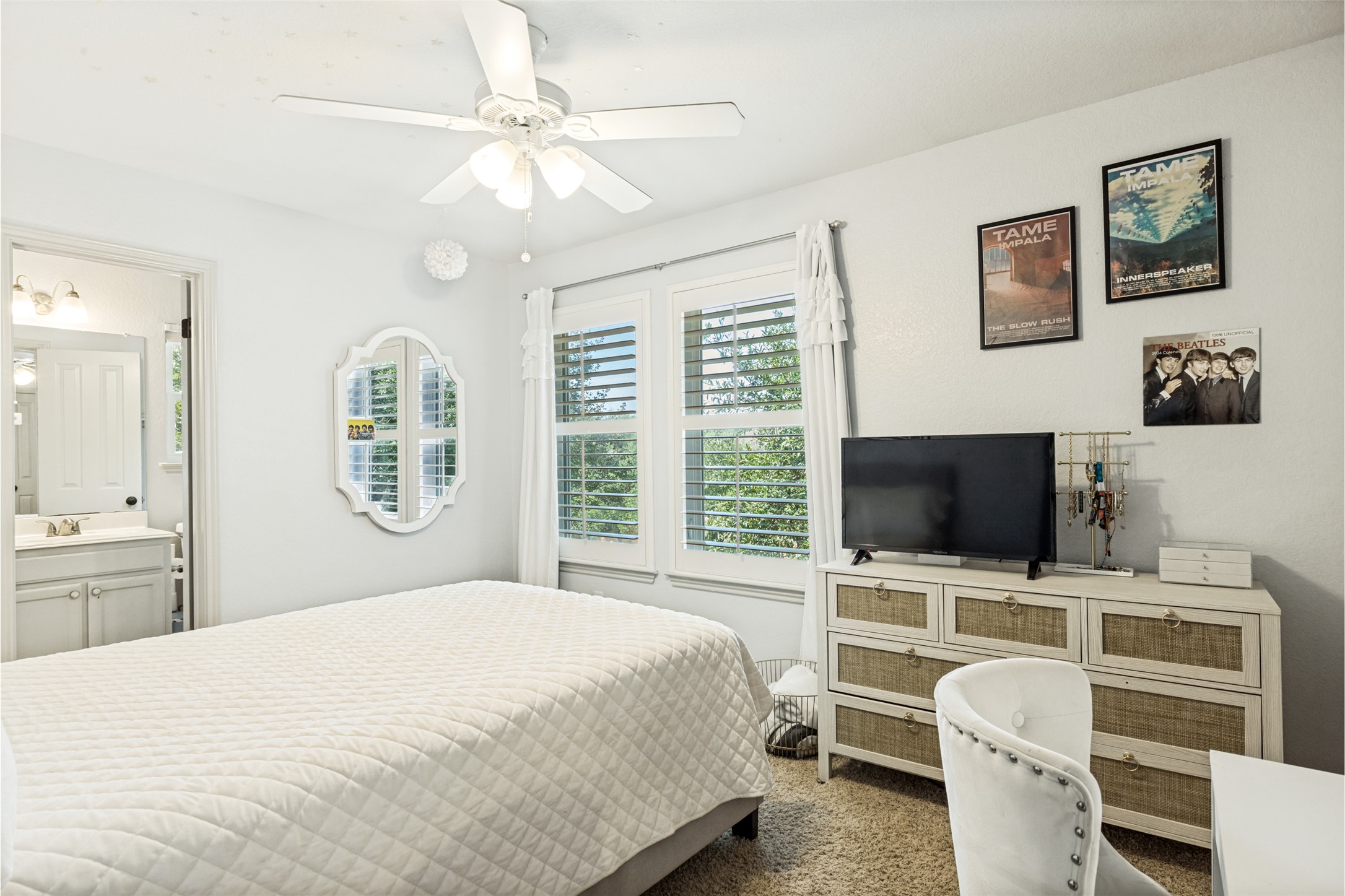 3803 Caney Creek Road Austin, TX 78732 - Photo 17 of 21 Sunlight streams through large shuttered windows into this comfortable bedroom with plush carpeting.