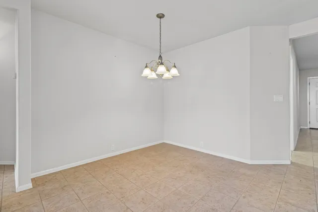 a view of a room with a hanging light and a window