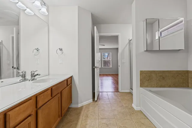 a bathroom with a tub sink and mirror