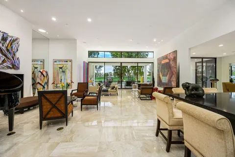 a hallway with painting on the wall and a large window