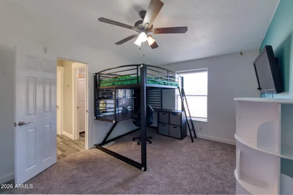 a bedroom with a baby bed chandelier and a window