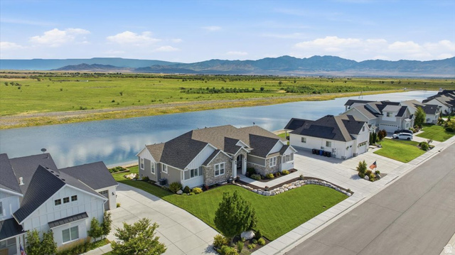 21 Pier Place Tooele, UT 84074 - Photo 4 of 112 Ranch-style residence featuring a stone and siding exterior, an attached multi-car garage, and a manicured front lawn