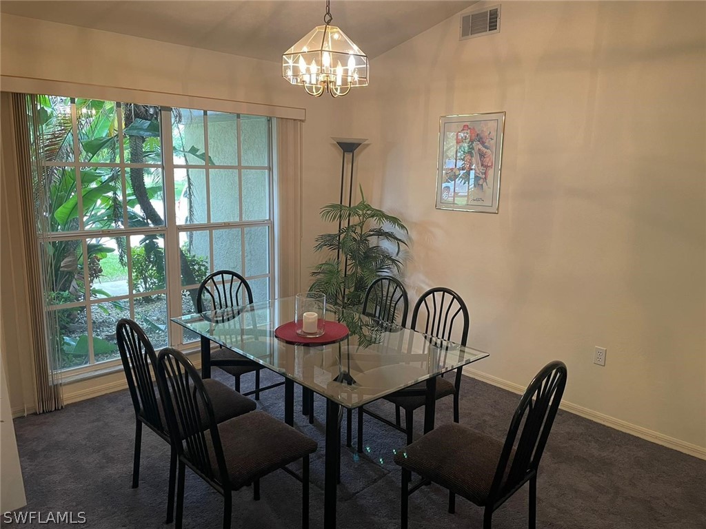 690 Morning Mist Lane Lehigh Acres, FL 33974 - Photo 13 of 20 a view of a dining room with furniture a chandelier and window