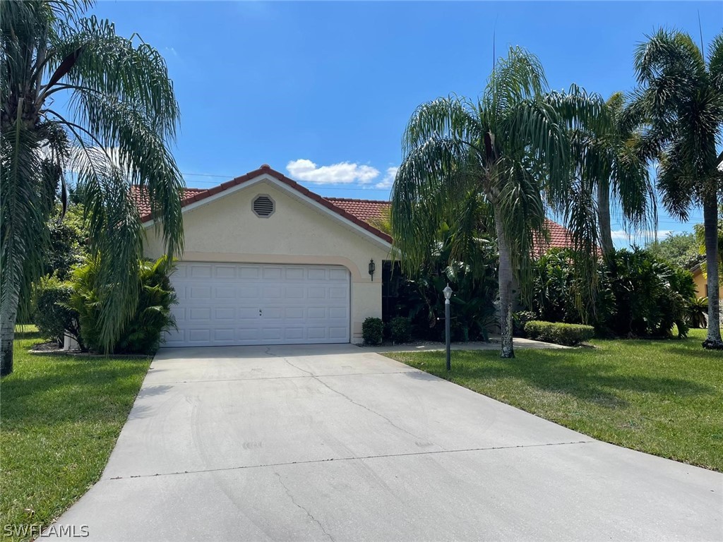 690 Morning Mist Lane Lehigh Acres, FL 33974 - Photo 2 of 20 a front view of house with yard and green space