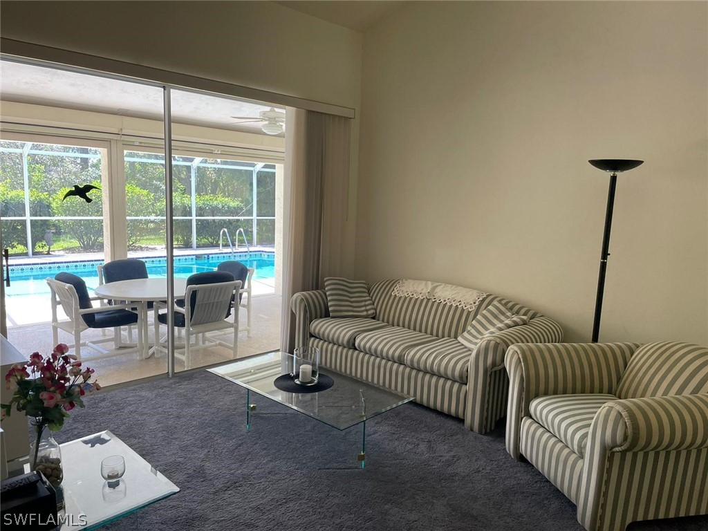 690 Morning Mist Lane Lehigh Acres, FL 33974 - Photo 5 of 20 a living room with furniture and a floor to ceiling window