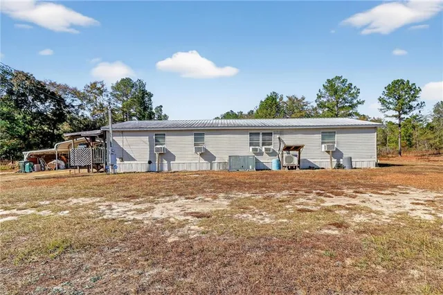 a front view of a house with a garden and trees