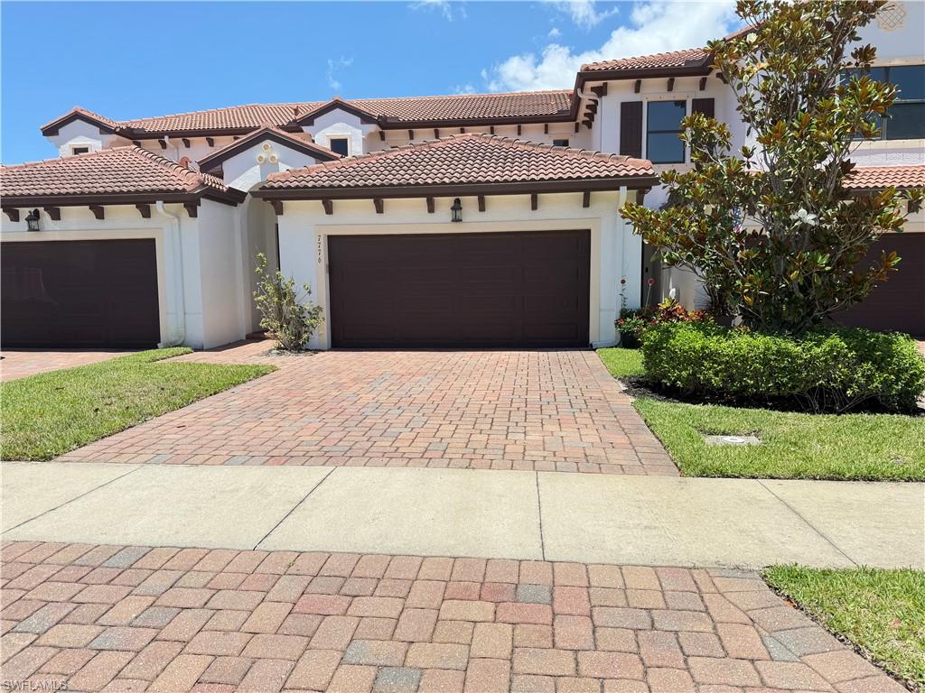 Mediterranean / spanish home featuring decorative driveway, stucco siding, a tile roof, and an attached garage