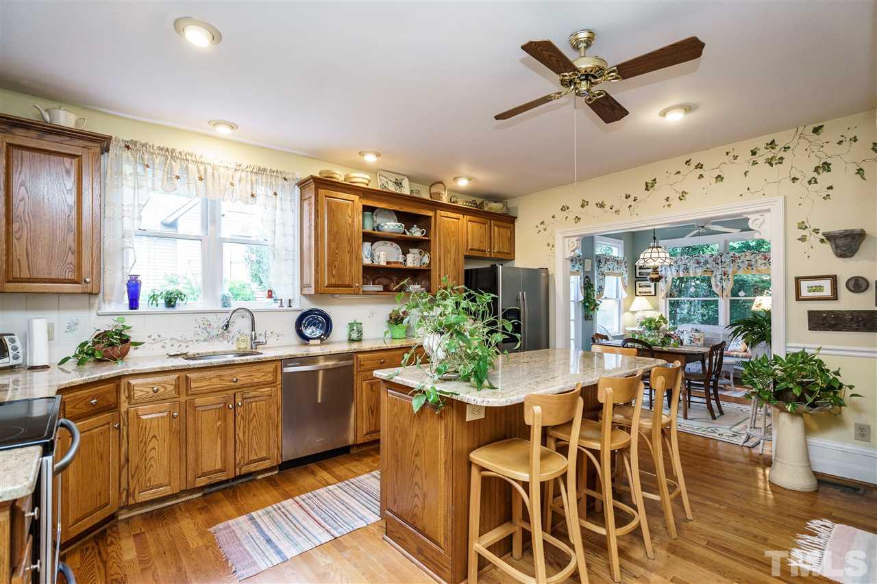 325 Polk Street Raleigh, NC 27604 - Photo 4 of 25 a kitchen with stainless steel appliances kitchen island granite countertop a table and chairs in it