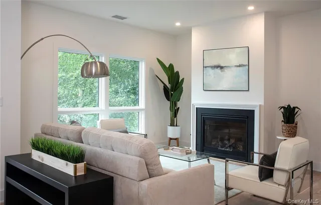 a living room with furniture a large window and a fireplace