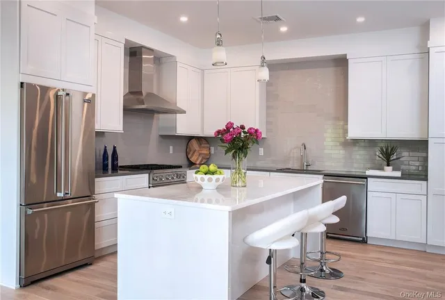 a kitchen with stainless steel appliances granite countertop a sink refrigerator and microwave