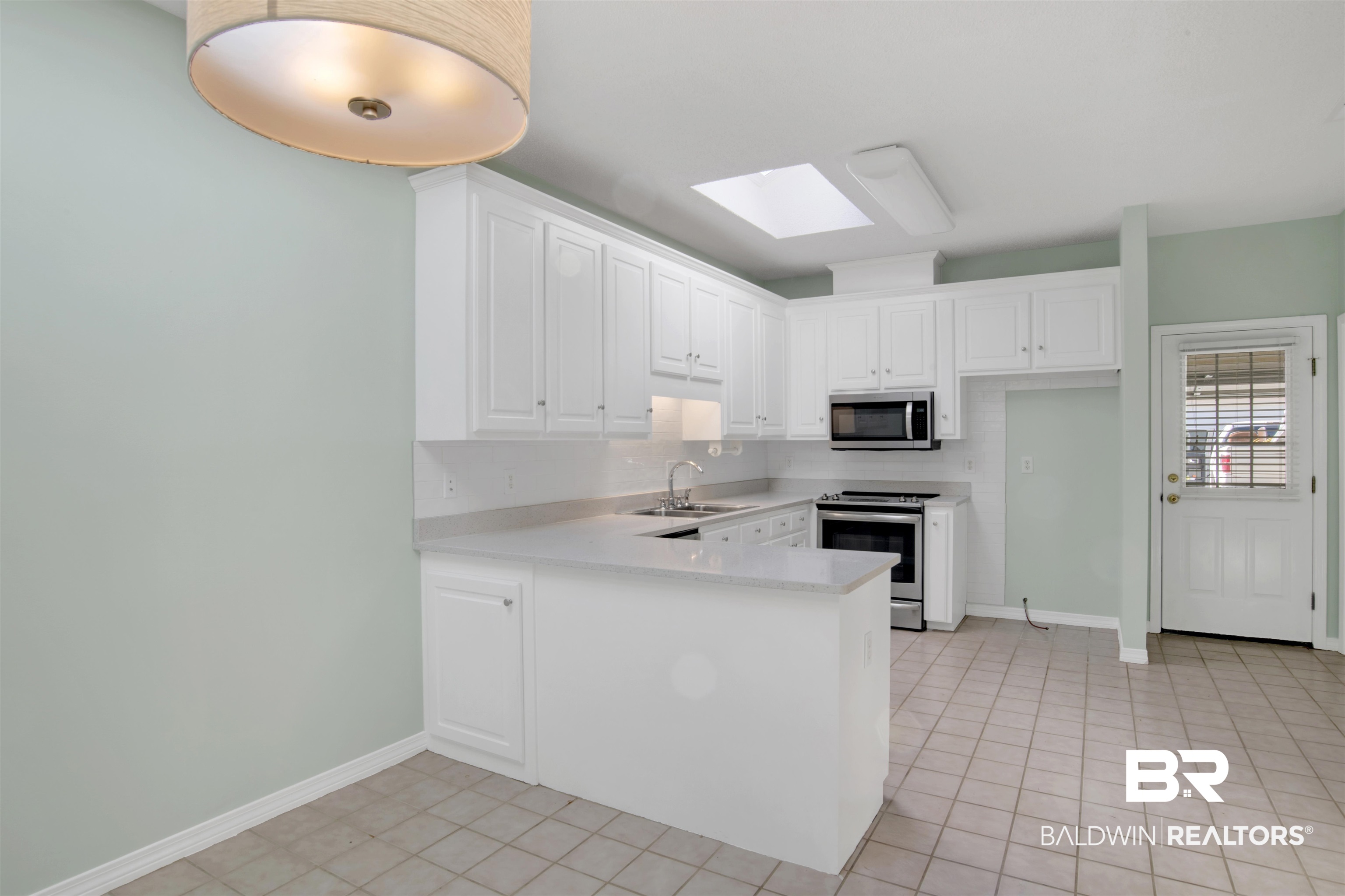 125 Woodruff Court Mobile, AL 36608 - Photo 14 of 27 Kitchen featuring white cabinetry, appliances with stainless steel finishes, sink, and kitchen peninsula
