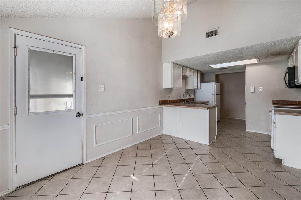 803 Canary Lane Mansfield, TX 76063 - Photo 10 of 25 a kitchen with granite countertop a refrigerator and a stove top oven