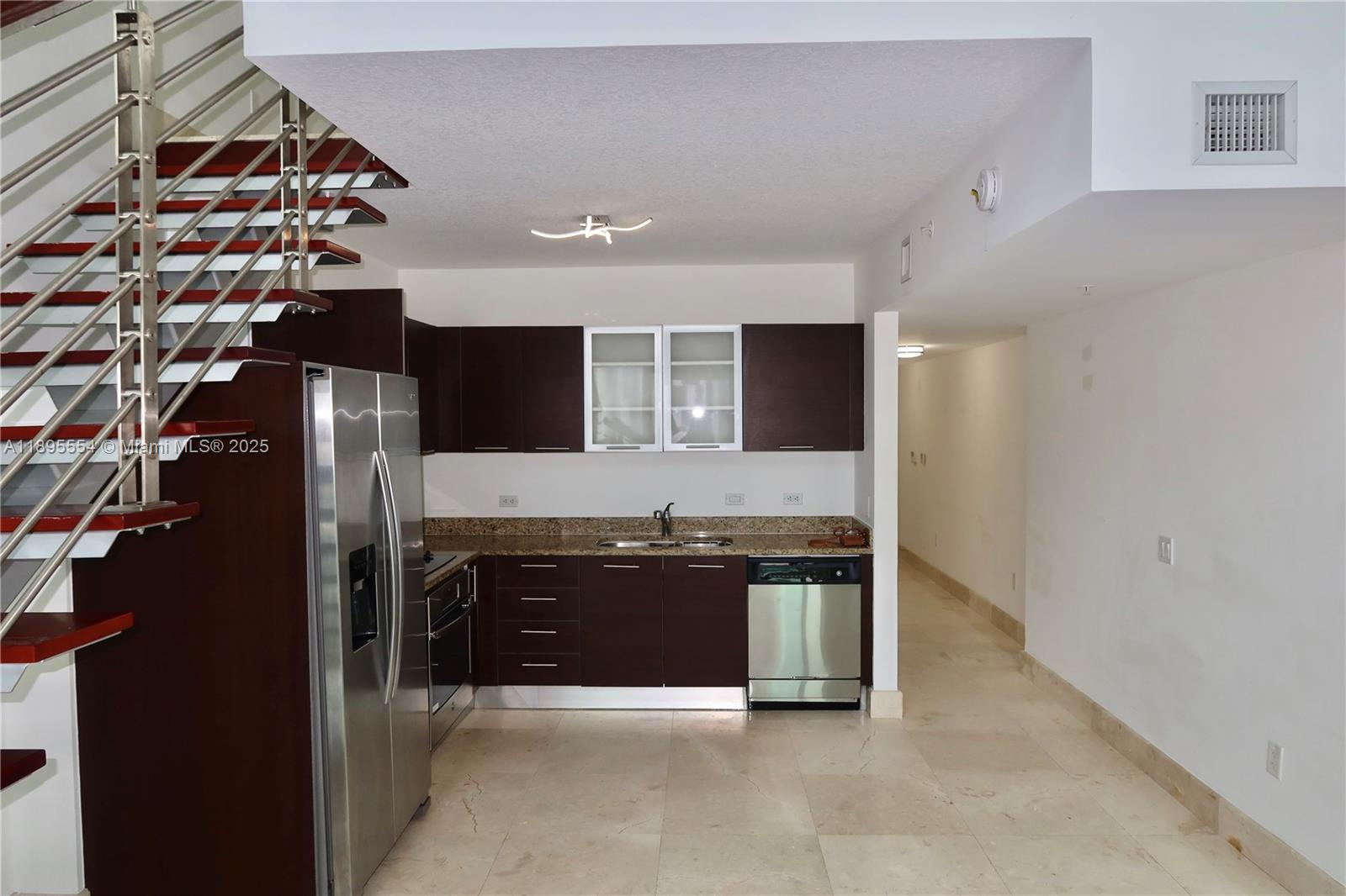 41 Southeast 5th Street, Unit 1611 Miami, FL 33131 - Photo 2 of 12 a large kitchen with stainless steel appliances granite countertop a sink and a stove